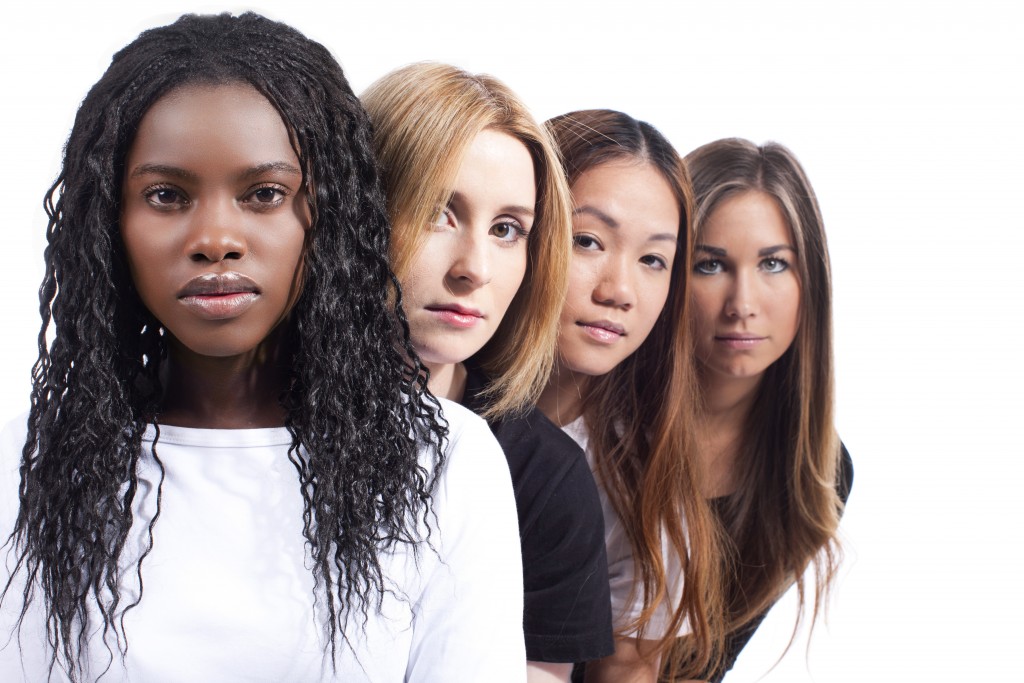 Vier junge Frauen verschiedener Herkunft hintereinander